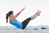 Woman doing pilates on exercise mat