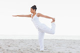 Brunette woman wearing all white stretching in yoga pose