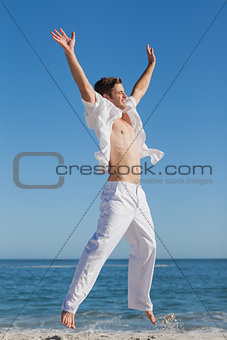 Attractive man jumping on beach