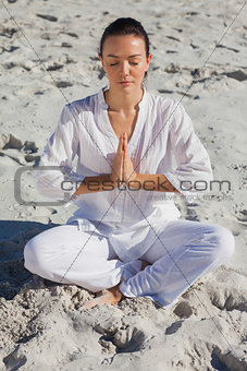Concentrated woman practicing yoga on the beach