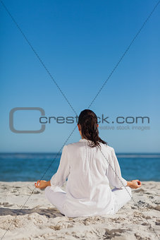 Woman sitting back to camera doing yoga