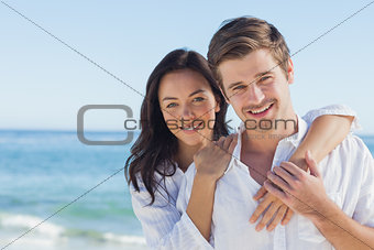 Cheerful couple embracing on the beach
