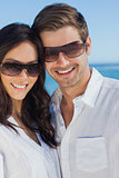 Happy couple wearing sunglasses and smiling at camera