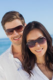 Young couple wearing sunglasses and smiling at camera