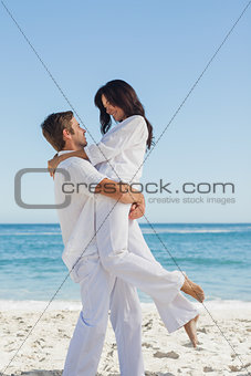 Happy man holding woman in arms