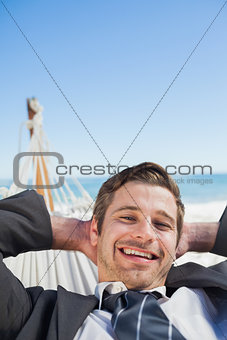 Smiling businessman relaxing in hammock