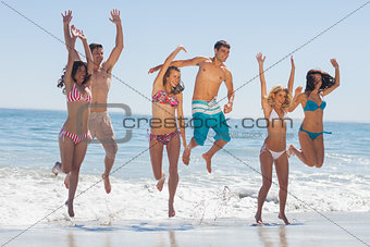 Happy friends jumping on the beach