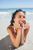 Close up view of smiling woman lying down on beach