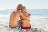 Rear view of a young couple sitting on the beach