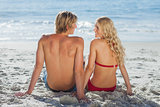 Happy couple sitting on beach
