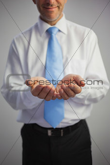 Close up of a pleased businessman joining his hands to the camera