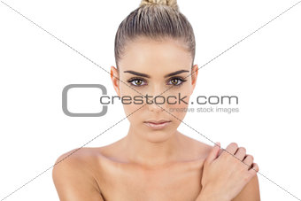Concentrated woman holding her shoulder and looking at camera