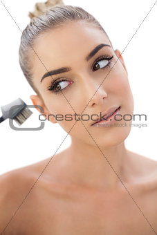 Concentrated woman looking at her make up brush