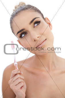 Thoughtful woman holding a toothbrush