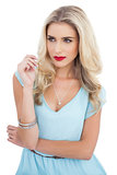 Attractive blonde model in blue dress looking away