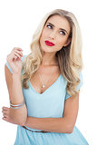 Seductive blonde model in blue dress looking away