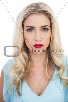 Portrait of a pensive blonde model in blue dress looking at camera