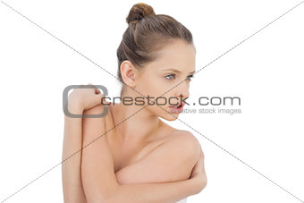 Stern brunette model posing holding her shoulders