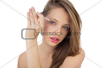 Focused brunette model plucking her eyebrows