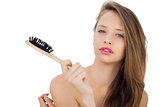 Pensive brunette model holding a hairbrush