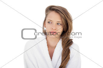 Thoughtful brunette in bathrobe looking away