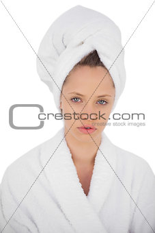 Serious brunette in bathrobe looking at camera