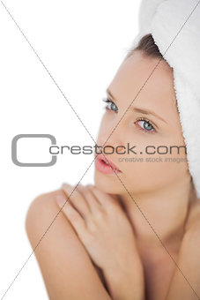 Concentrated brunette drying her hair looking at camera