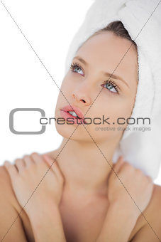 Pensive brunette drying her hair looking away