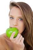 Serious brunette model eating an apple