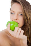 Thoughtful brunette model eating an apple
