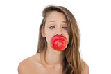 Concentrated brunette model holding an apple in her mouth