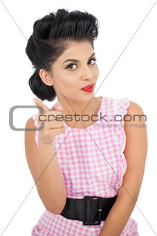 Pleased black hair model pointing a figer at camera