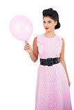 Pleased black hair model holding a pink balloon