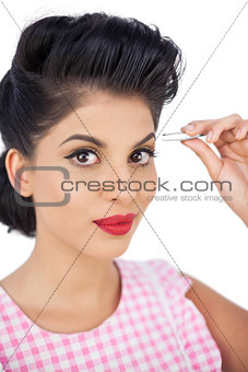 Gorgeous black hair model using a tweezer