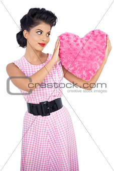 Stylish black hair model holding a pink heart shaped pillow
