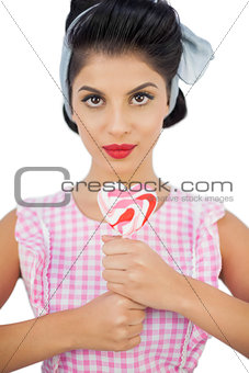 Charming black hair model holding a heart shaped lollipop