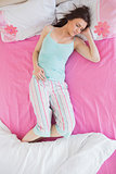 Brunette in pajamas sleeping on bed