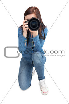 Pretty young photographer taking picture of camera