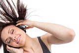Smiling pretty brunette tossing her hair while listening to music