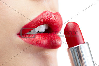 Extreme close up on model applying red lipstick