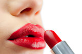Extreme close up on red lips being made up