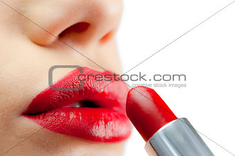 Extreme close up on red lips being made up