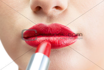 Extreme close up on beautiful red lips being made up