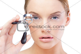 Pretty blonde model using eyelash curler