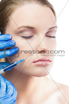 Relaxed gorgeous model having botox injection on the cheek