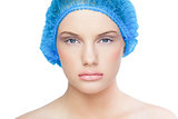 Serious pretty model wearing blue surgical cap
