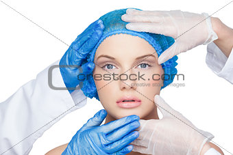 Surgeons examining calm blonde wearing blue surgical cap