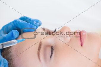 Surgeon making injection on natural woman lying