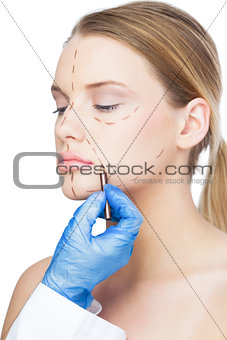 Surgeon drawing dotted lines on beautiful patient