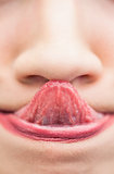 Extreme close up on woman touching her nose with her tongue